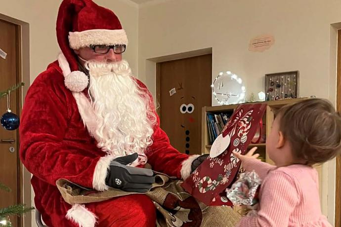 Jõuluvana ulatab tüdrukule kingitust