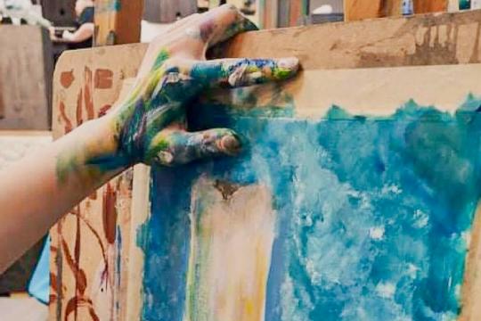 Lapse värvine käsi toetub maalile